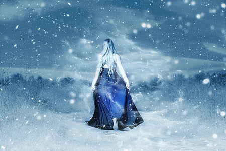 woman in blue dress surrounded by snowy trees photo