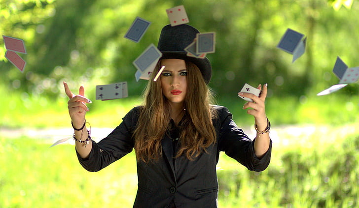 woman wearing black shirt and hat playing cards