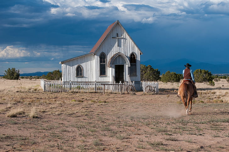 man riding horse near church
