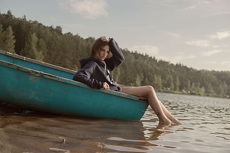 woman sitting on teal boat