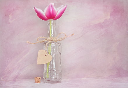 clear glass bottle with pink flower