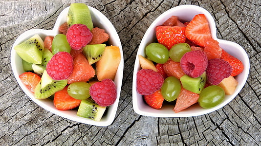 sliced fruits inside white ceramic heart-shaped bowls