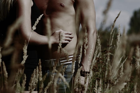 closeup photo of topless man and woman standing on field