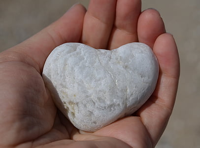 person holding white heart stone