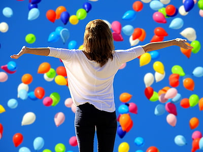 woman in white blouse under assorted-color balloons