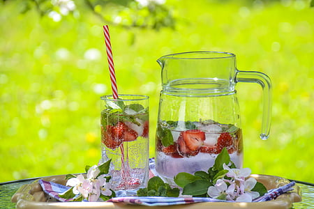 clear glass pitcher beside drinking glass with strawberry juice