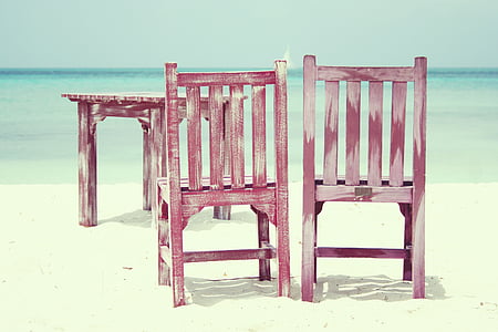 two red wooden chairs on shore at daytime
