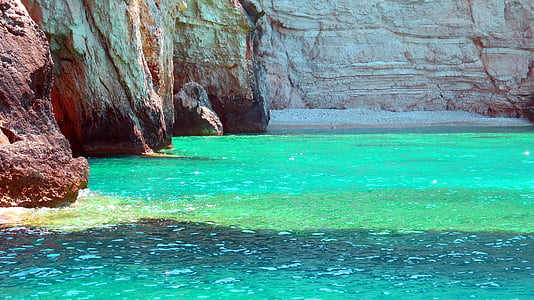 green-tinted clear body of water near brown cliffs