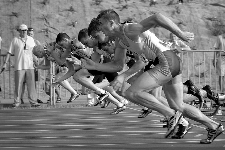 grayscale photo of athletes running in field