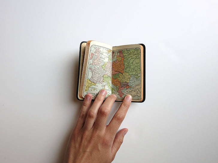 person opening a booklet of map