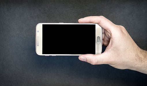 person holding brown Samsung smartphone sidewards