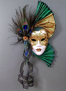 white, brown, and green mask with peacock tails