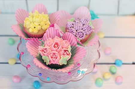 three assorted cupcakes on clear glass bowl