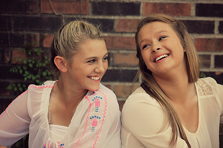 two girl wearing white scoop-neck shirts