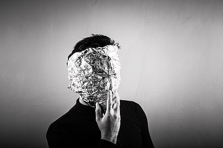 grayscale photo of man with foil wrap on his face