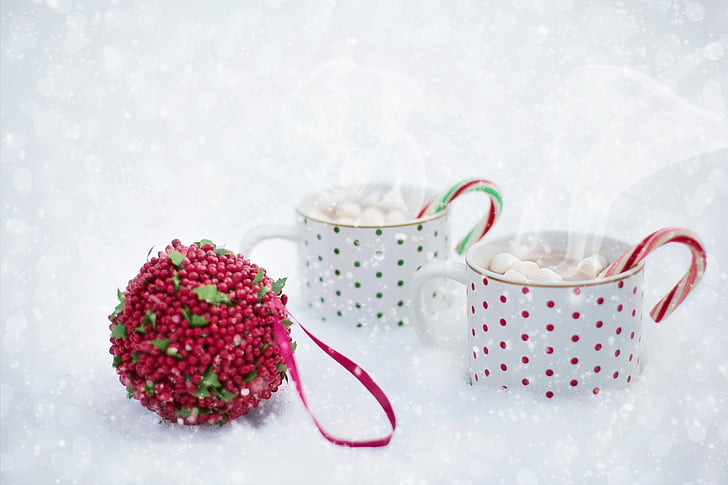 two white-and-red polka-dot mugs filled with marshmallows