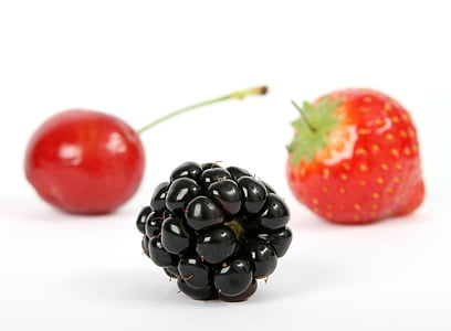 oval black fruit near cherry and strawberry fruit