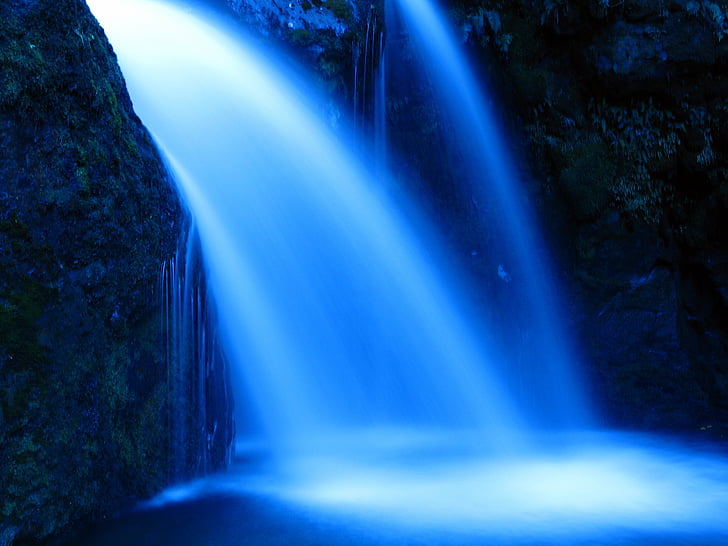 waterfall inside cave during night time