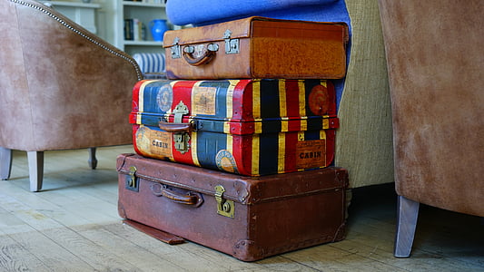 three assorted-color luggage bags near sofa