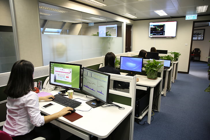 group of people sitting in front of desk working on their cubicles