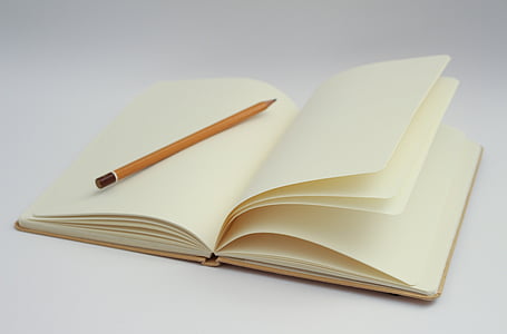 white open notebook and pencil photo
