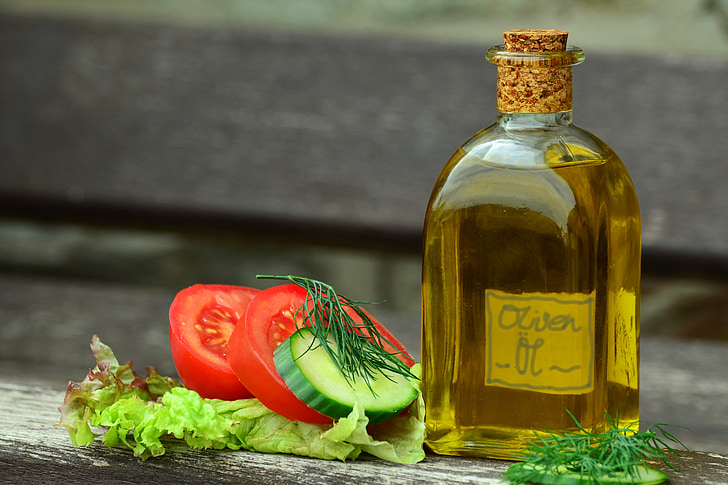 olive oil bottle and sliced tomatoes in shallow focus photography
