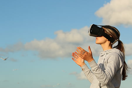 woman wearing black and white VR goggles
