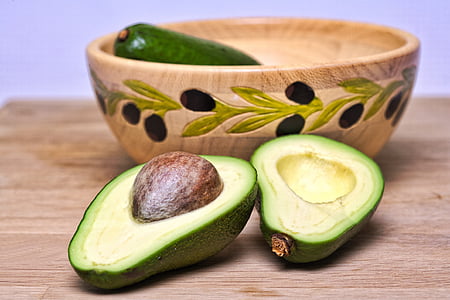 green sliced avocado on brown wooden table top