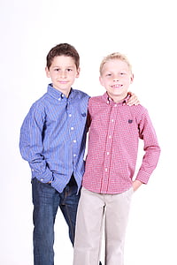 two boys in red and blue button-up sport shirts and denim pants