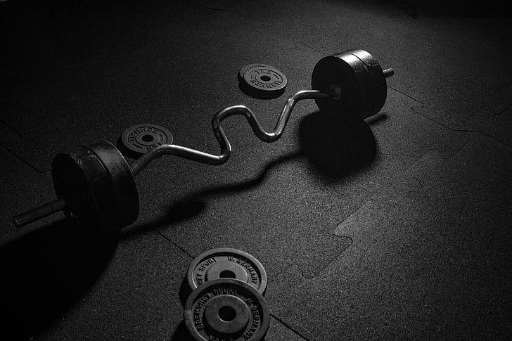 grayscale photo of ez curl barbell and weight plates