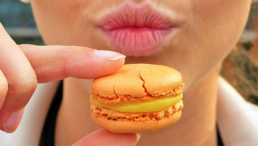 person holding macaroon during daytime