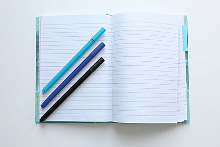 three color pens on top of notebook
