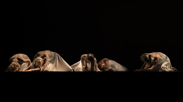 five women wearing white dress kneeling on floor
