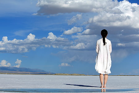 woman wearing white dress while standing on flat surface