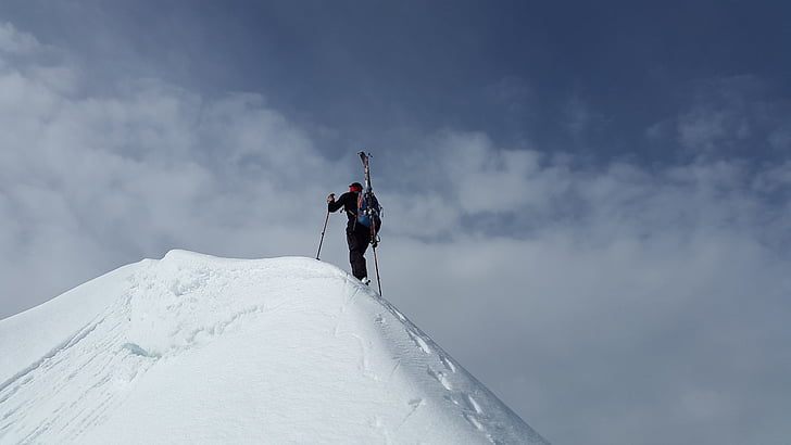 man climbing on top of snow mountain