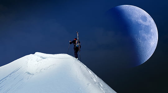 person climbing on snowy mountain