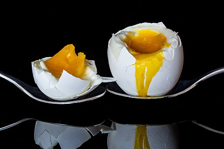 two poultry eggs on spoon