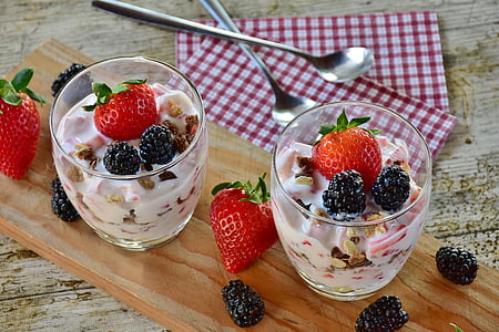 two fruit salad in clear glasses near two spoons