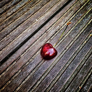 red cherry on black and brown surface