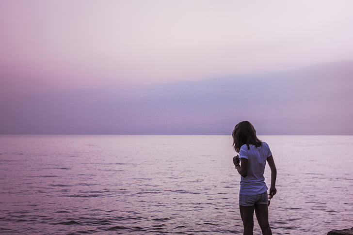 landscape photo of woman standing in front of sea