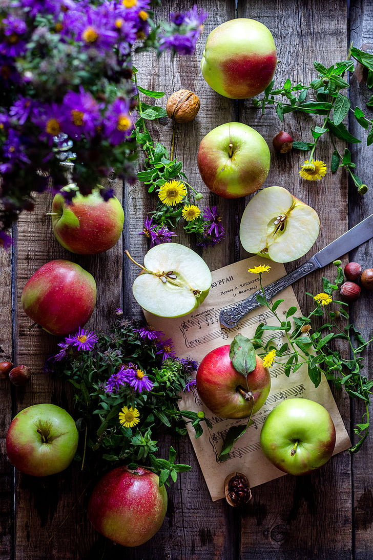 apples and flowers on table