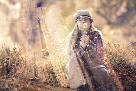 girl blowing dandelion