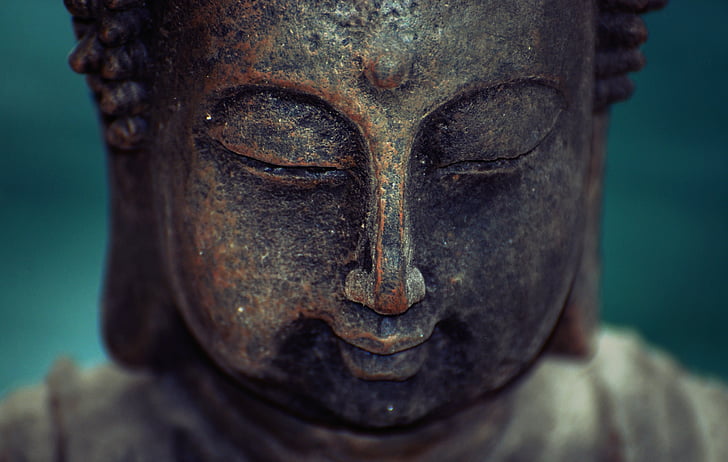 brass-colored buddha face statue
