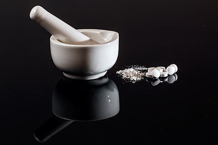 white mortar and pestle on black surface