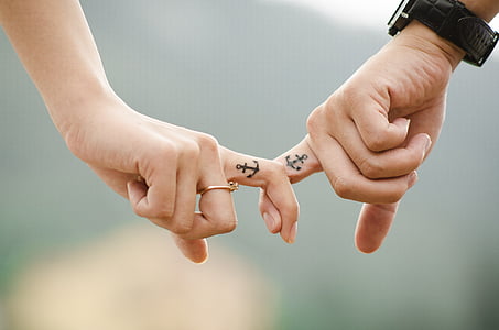 two person showing anchor finger tattoos