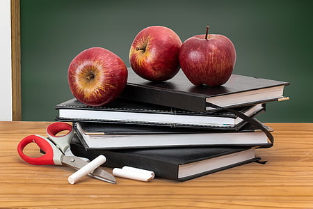 ripe apples on notebook pile