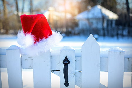 white wooden fence with santa hat on top